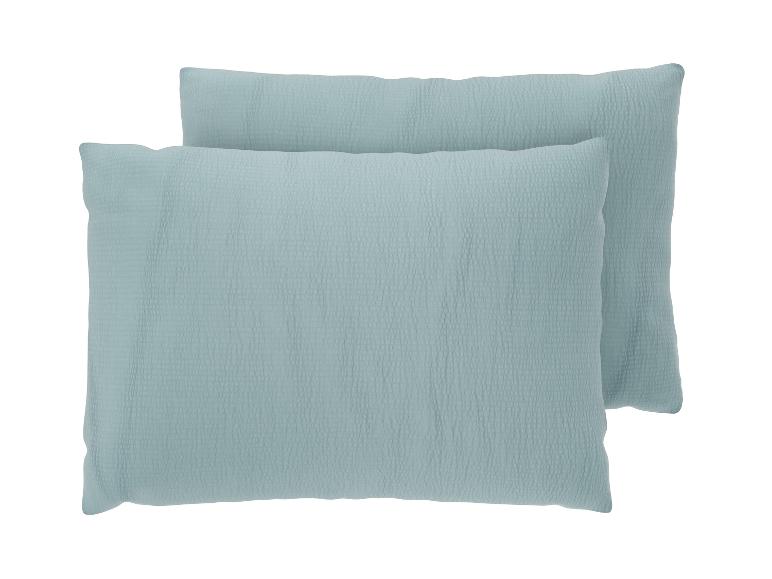 Deux oreillers bleu clair avec une texture froissée.