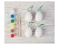 Kit de peinture d'œufs de Pâques avec œufs blancs, peintures et pinceaux sur fond en bois.