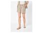 Femme en short beige à cordon, chemise assortie et sandales plates.