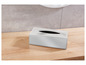 Un distributeur de mouchoirs en argent sur une table en bois.