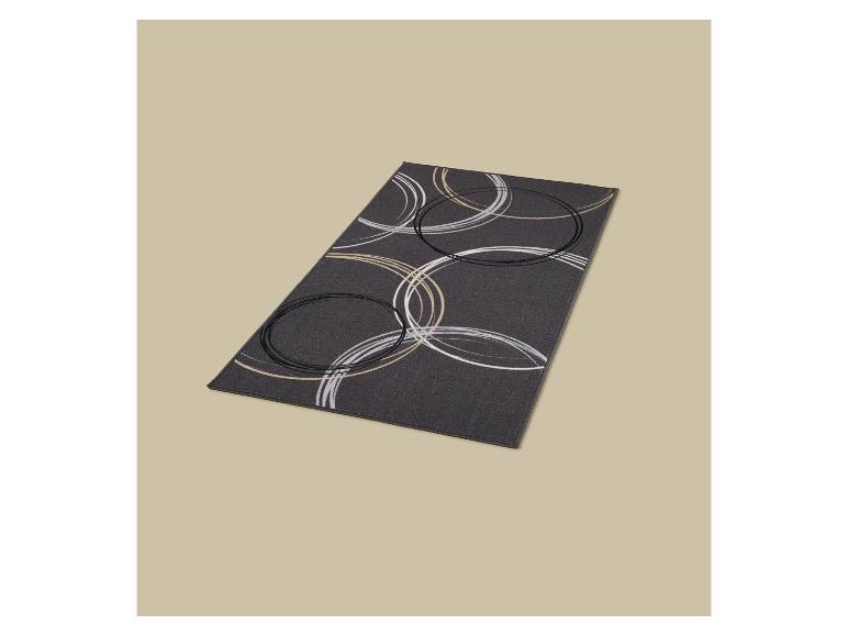 Tapis gris foncé avec des motifs circulaires abstraits blancs, noirs et beiges