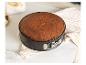 Un gâteau au chocolat cuit dans un moule à charnière sur un comptoir en marbre.