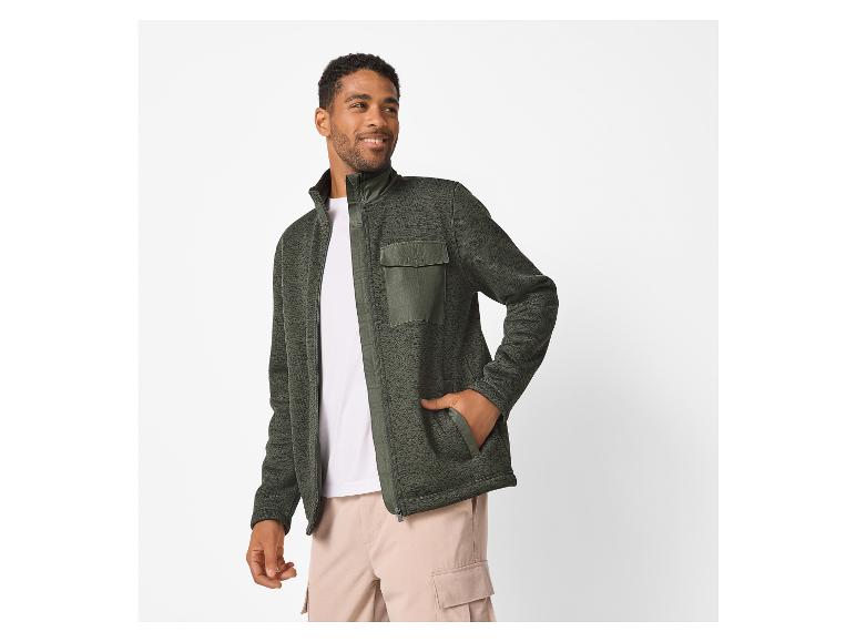 Homme en veste polaire verte et t-shirt blanc, souriant
