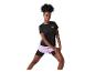 Femme en t-shirt de sport noir et short lilas faisant des étirements.