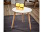 Une table basse ronde avec des pieds en bois et deux bougies décoratives.