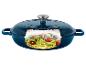 Cocotte en fonte bleue avec couvercle, remplie de spaghettis de courgettes, tomates et pignons.