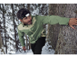 Homme avec lampe frontale et veste verte dans une forêt enneigée.
