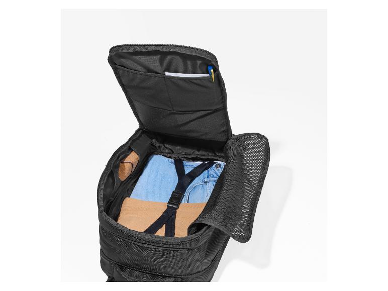 Sac à dos noir ouvert avec vêtements et effets personnels à l'intérieur.