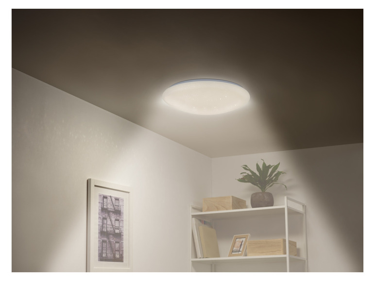 Un luminaire de plafond rond avec éclairage LED intégré dans un salon moderne.