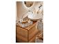 Rangement salle de bain : paniers tressés, produits de beauté et meuble en chêne.