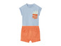 Ensemble bébé avec un t-shirt bleu clair avec un motif de plante dans la poche et un short orange.