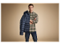 Modèle masculin portant une chemise à carreaux et une veste matelassée.