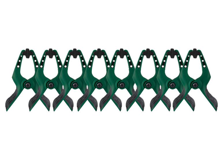 Huit serre-joints à ressort verts et noirs avec poignées caoutchoutées, alignés.