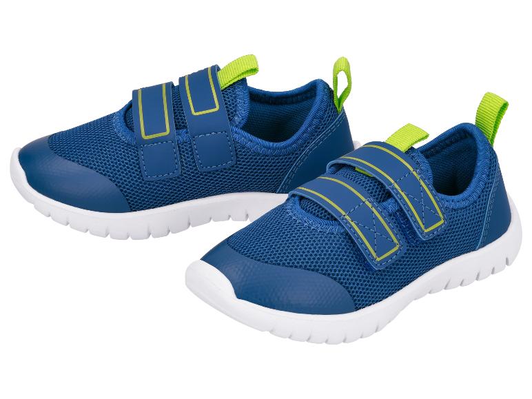Une paire de chaussures de sport bleues pour enfants avec des accents verts et des semelles blanches.