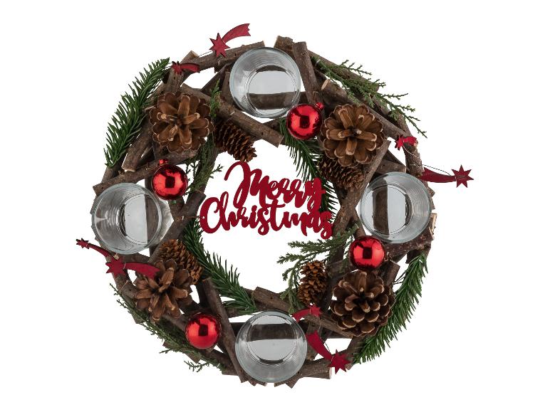 Une couronne de Noël avec des bougeoirs, des pommes de pin et des décorations rouges.