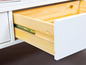 Un tiroir blanc ouvert avec un intérieur en bois.