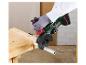 Meuleuse d'angle sans fil Parkside coupant un tuyau métallique sur un établi en bois.