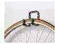 Roue de vélo suspendue à un support mural noir avec des embouts verts