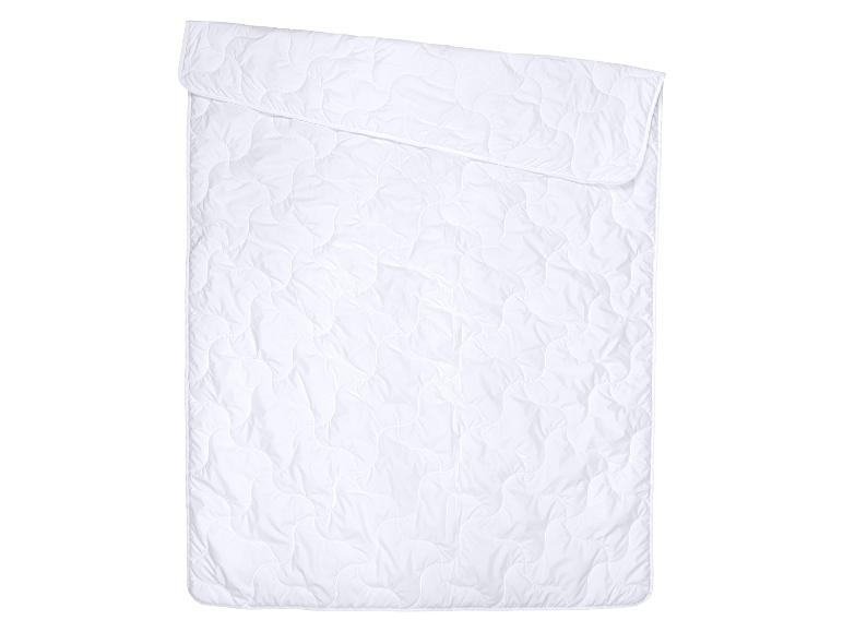 Couette blanche matelassée avec un motif ondulé.
