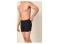 Homme en caleçon noir, ajustant la ceinture.
