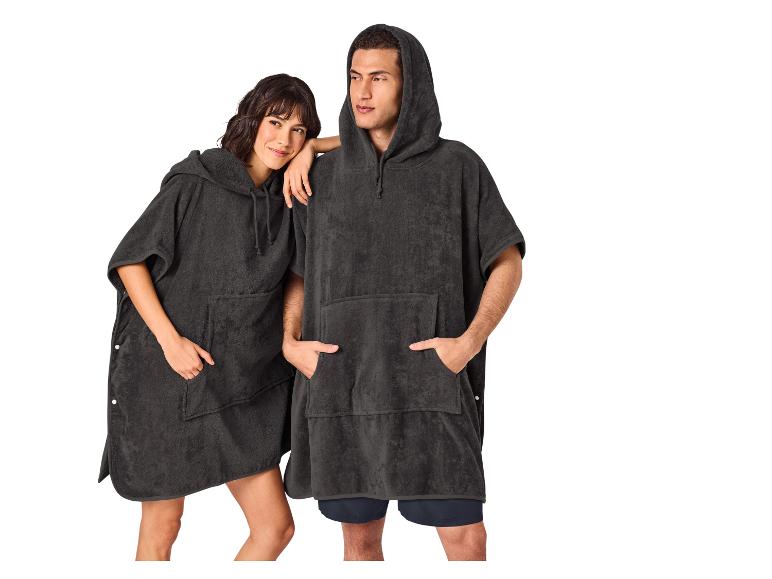 Deux personnes en ponchos de bain foncés avec capuches et poches.