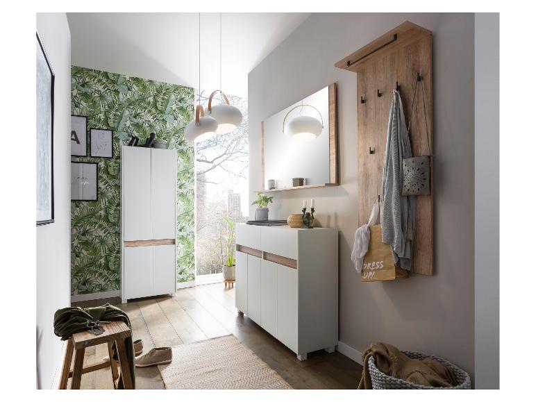 Entrée moderne avec armoires blanches, miroir, porte-manteau en bois et papier peint à feuilles.