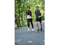 Deux coureurs en tenue de sport faisant du jogging en extérieur, femme en veste et homme en gilet.