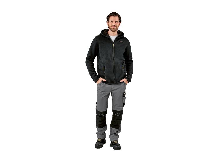 Homme en sweat à capuche noir Parkside et pantalon de travail gris.