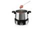 Un set de fondue avec une fraise trempée dans du chocolat.