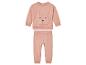 Un sweat-shirt rose avec des oreilles de lapin et un pantalon assorti.