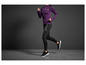 Une femme court en leggings noirs et un pull violet.