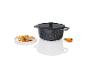 Une casserole noire avec un couvercle et des légumes cuits dans une assiette