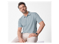 Un homme porte un polo bleu clair et un pantalon beige.
