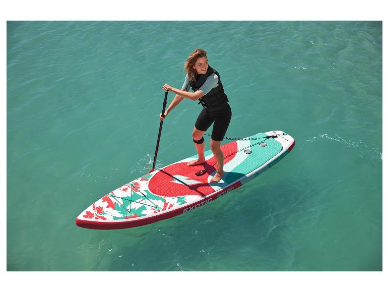 Femme pagayant sur une planche de paddle gonflable Exotic 10'6″, motif floral.