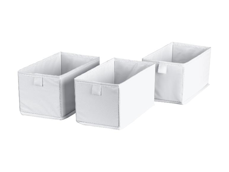 Trois boîtes de rangement en tissu blanc sur fond blanc.