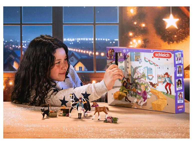 Fille ouvrant un calendrier de l'avent Schleich Horse Club avec des jouets de chevaux.