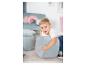 Garçon heureux jouant avec des poufs et coussins doux, bleu clair, dans une chambre d'enfant.