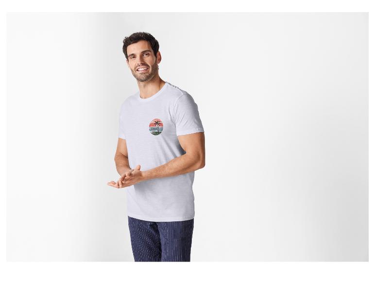 T-shirt homme blanc à motif plage estival et pantalon rayé.