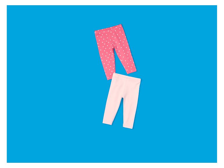 Deux paires de leggings pour enfants : un rose à pois blancs et un rose clair uni.