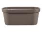 Un pot de fleurs ovale en plastique de couleur gris foncé.