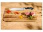 Couteau de cuisine avec épices, viande et légumes sur une planche en bois.