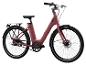 Un vélo électrique rose avec une transmission par courroie et des pneus Schwalbe.