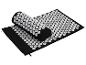 Un tapis et un coussin d'acupression noirs avec des picots blancs.
