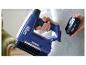 Femme tient une agrafeuse sans fil RAPID 18 V BTX553 bleue et une batterie de 2,5 Ah.