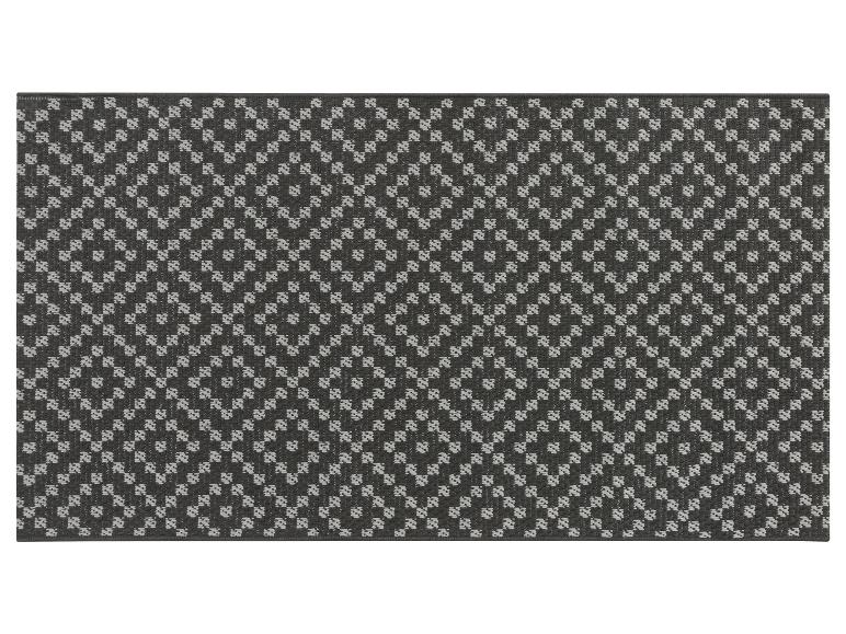 Un tapis gris foncé avec un motif géométrique blanc.
