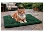 Un chat roux allongé sur un tapis chauffant vert Karlie sur la terrasse.