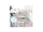 Chaise haute pour bébé avec plateau et harnais de sécurité, à côté d'une table avec bol et tasse.