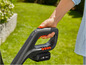 Une main tenant une paire de ciseaux de jardin sans fil noirs avec un bouton rouge.