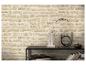 Mur avec papier peint beige à motif de pierre, étagère noire avec livres et objets décoratifs.
