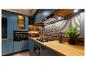Cuisine moderne avec armoires bleues, comptoir en bois, cuisinière à gaz et prise escamotable.